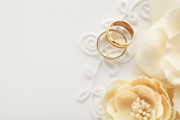 Gold Wedding Rings with Flowers on White Background